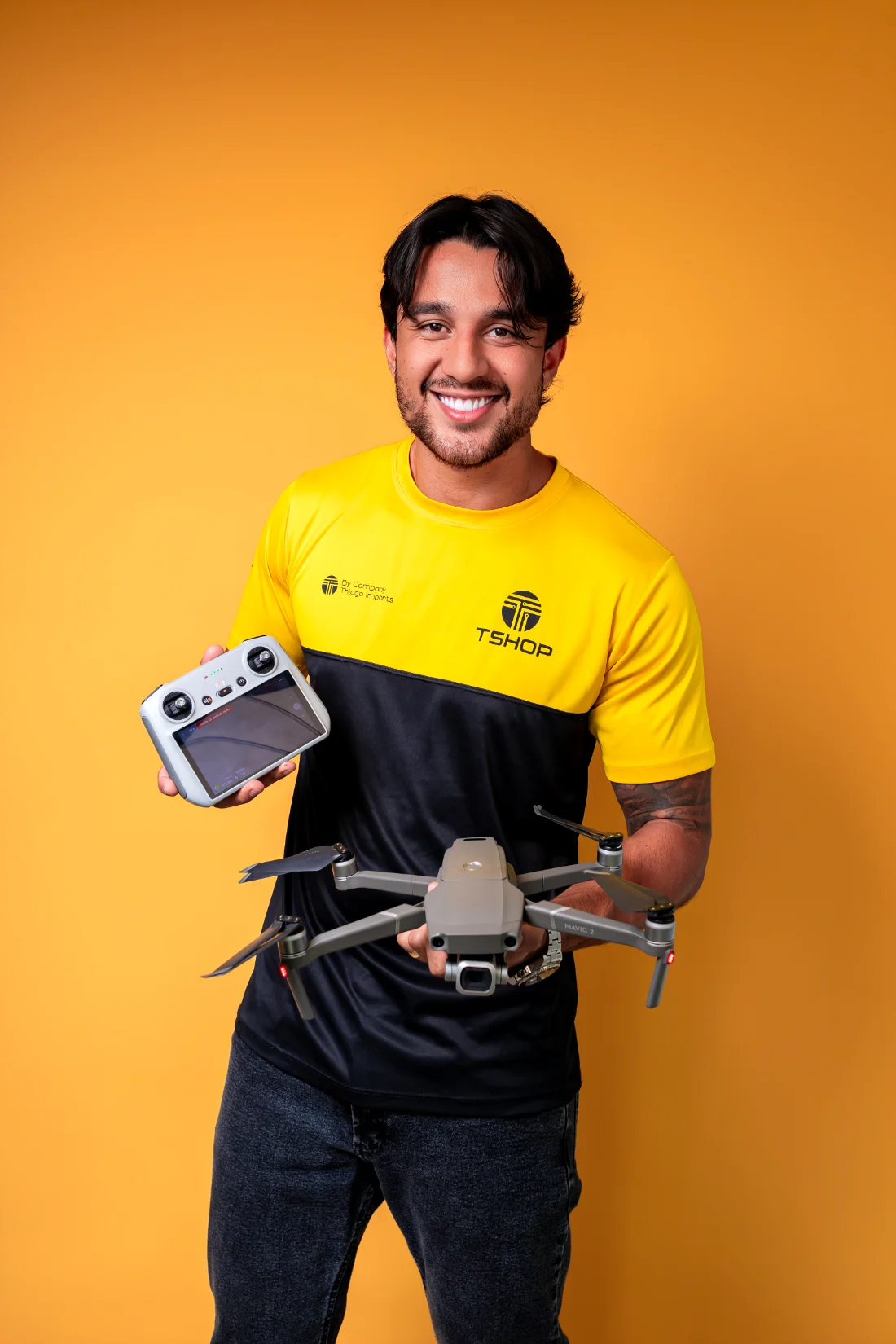 Thiago segurando um drone DJI e o controle